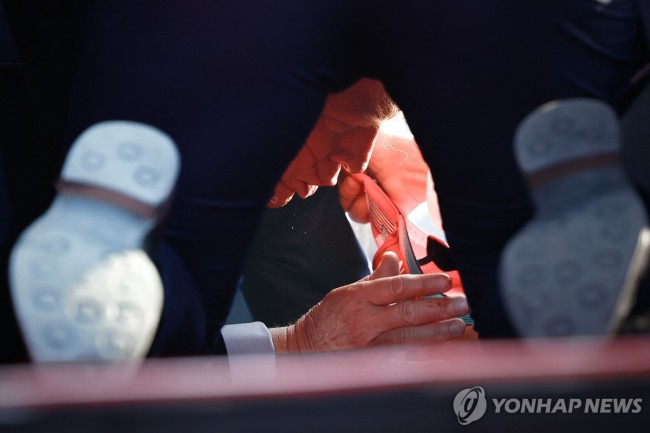 유세 중 총격으로 엎드려 피신한 트럼프 전 미국 대통령