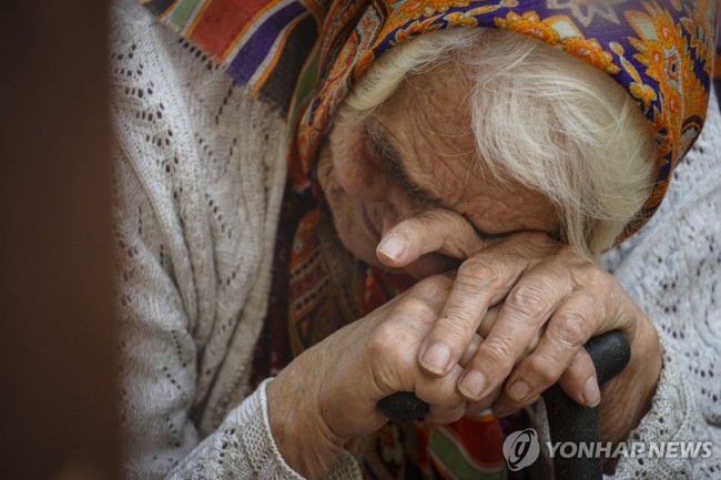 쿠르스크에서 피란한 한 노인이 구호물자를 받으려 기다리는 모습