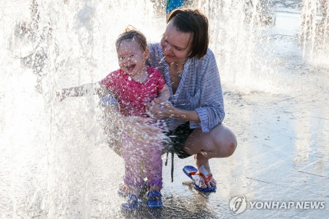 러시아 모스크바서 아기와 분수 즐기는 여성