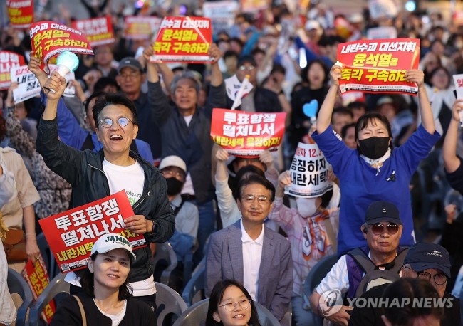 출구조사 결과 공개에 기뻐하는 촛불행동 집회 참가자들